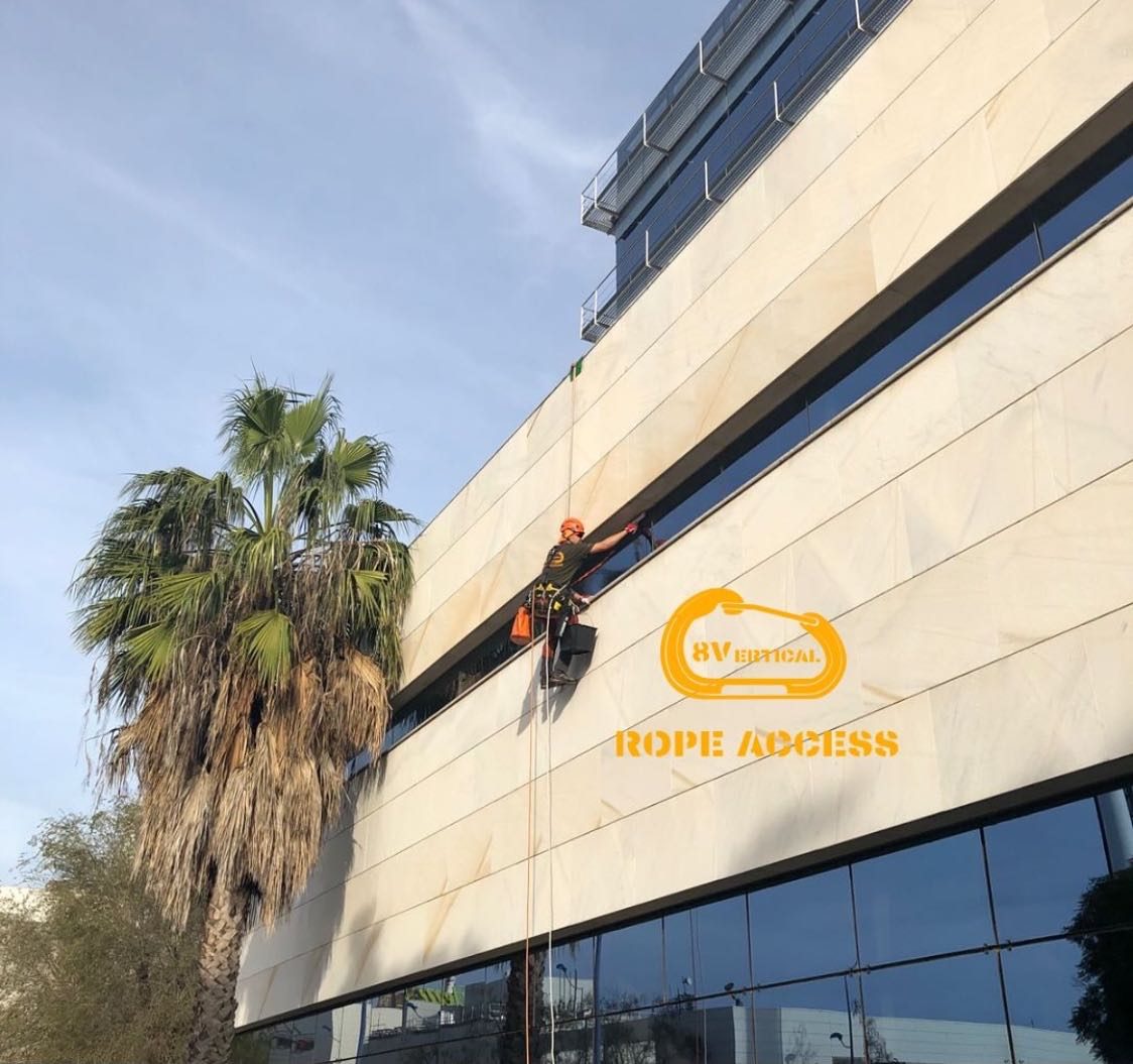 Técnico trabajando en la fachada de un edificio