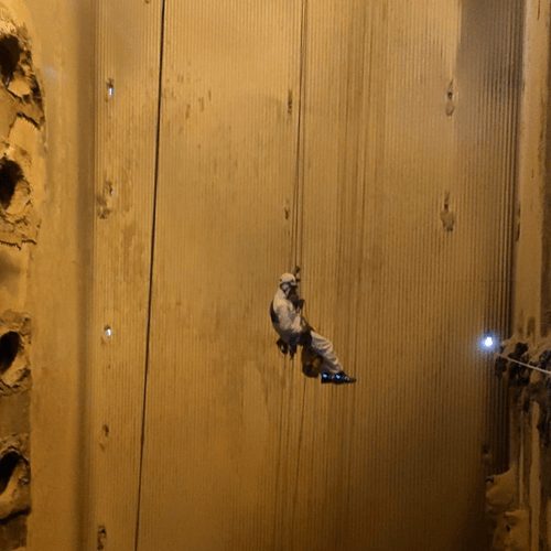 Técnico descendiendo por el interior de una nave industrial