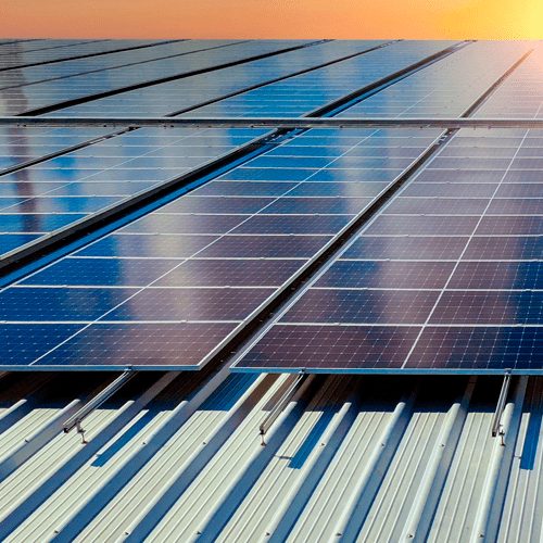 Placas solares instaladas en cubierta industrial al atardecer